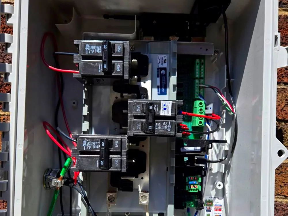 An AC combiner enclosure with breakers, labelled conductors and tidy grounding