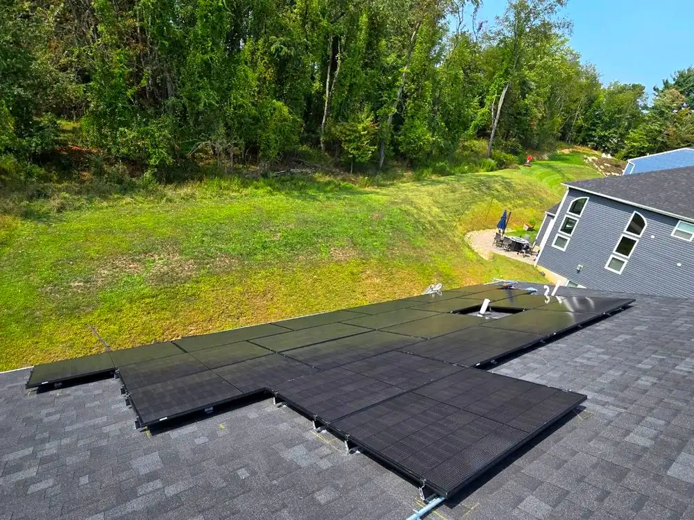 A finished all-black solar array on a residential shingle roof, photographed from above