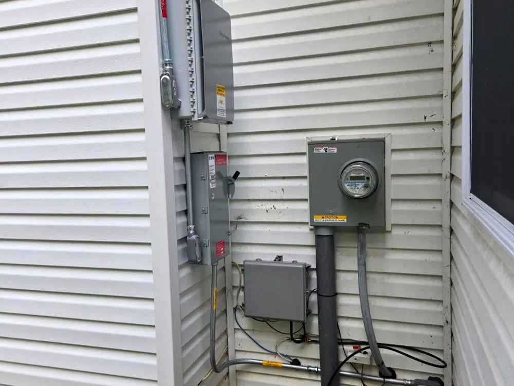 Exterior wall with the utility meter, an AC disconnect and a junction box neatly installed